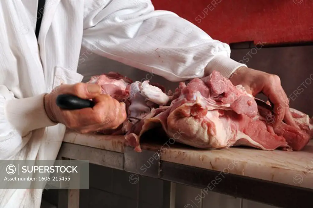 France, Paris, a butcher prepares a shoulder of veal with a knife