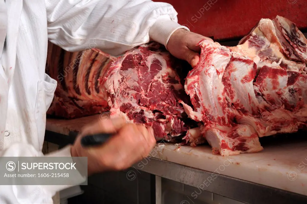 France, Paris, a butcher prepares a rump steack with a knife