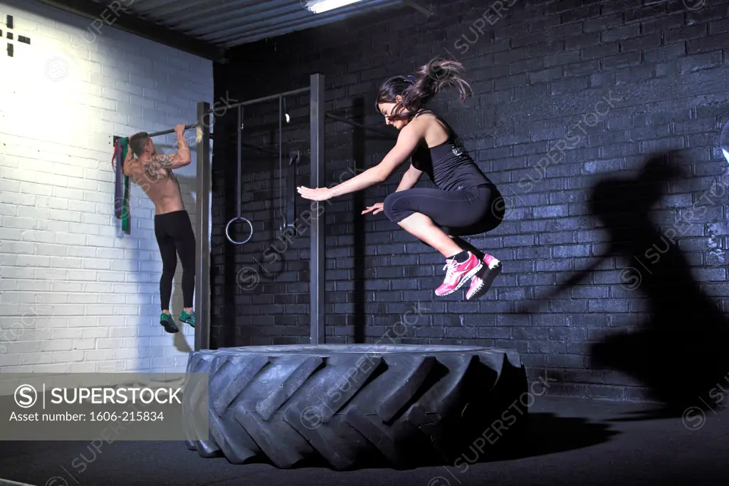 France, jumping woman in crossfit gymnasium.