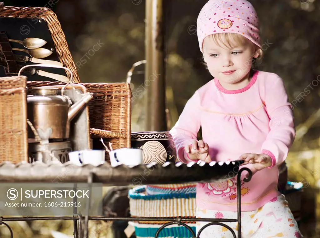 Little girl playing with tea set