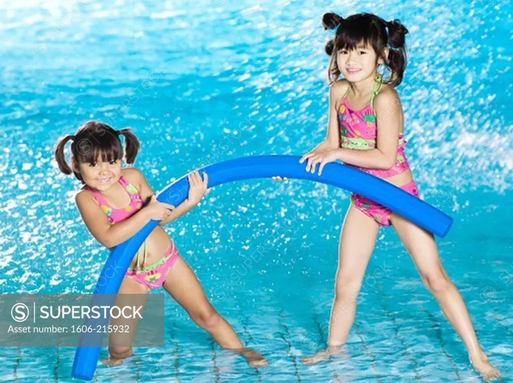 Two grils playing with pool noodle