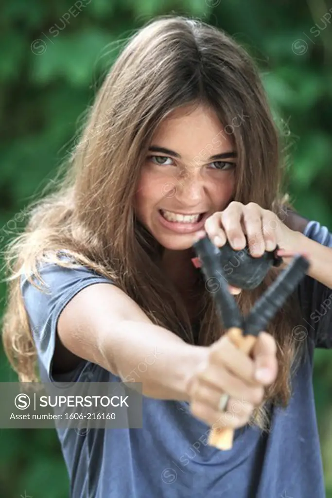 France, young girl using slingshot.
