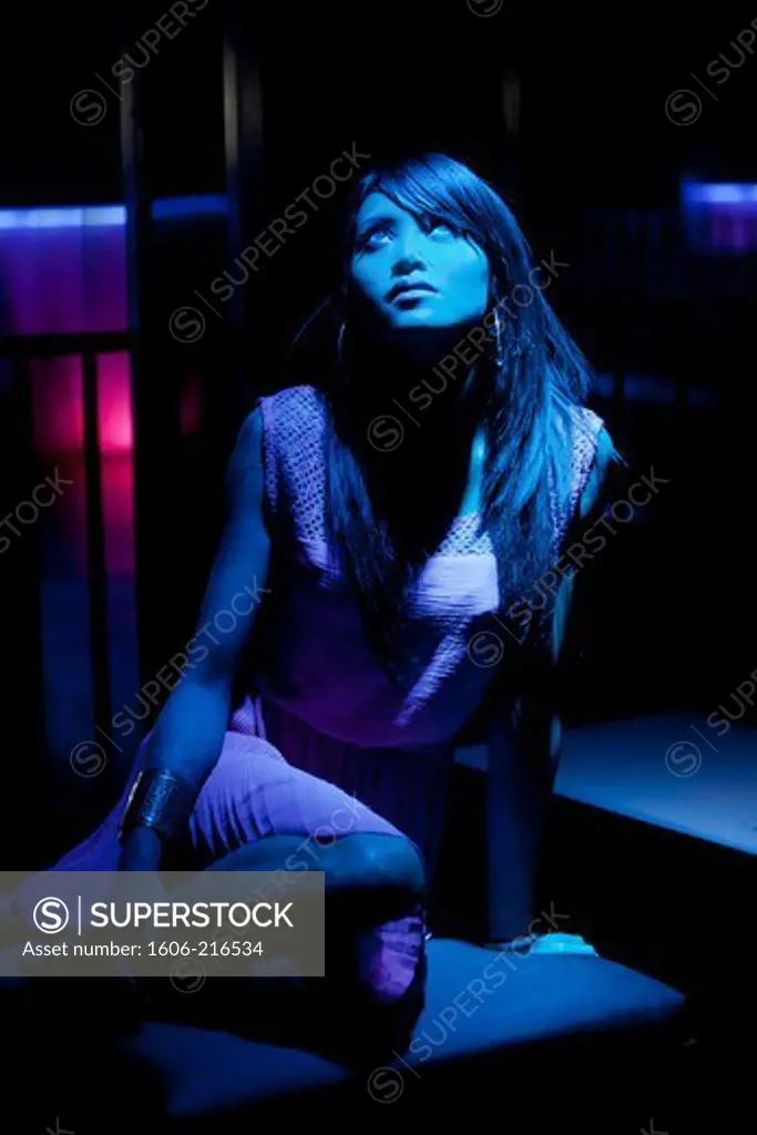 Young asian woman sitting in the blue light