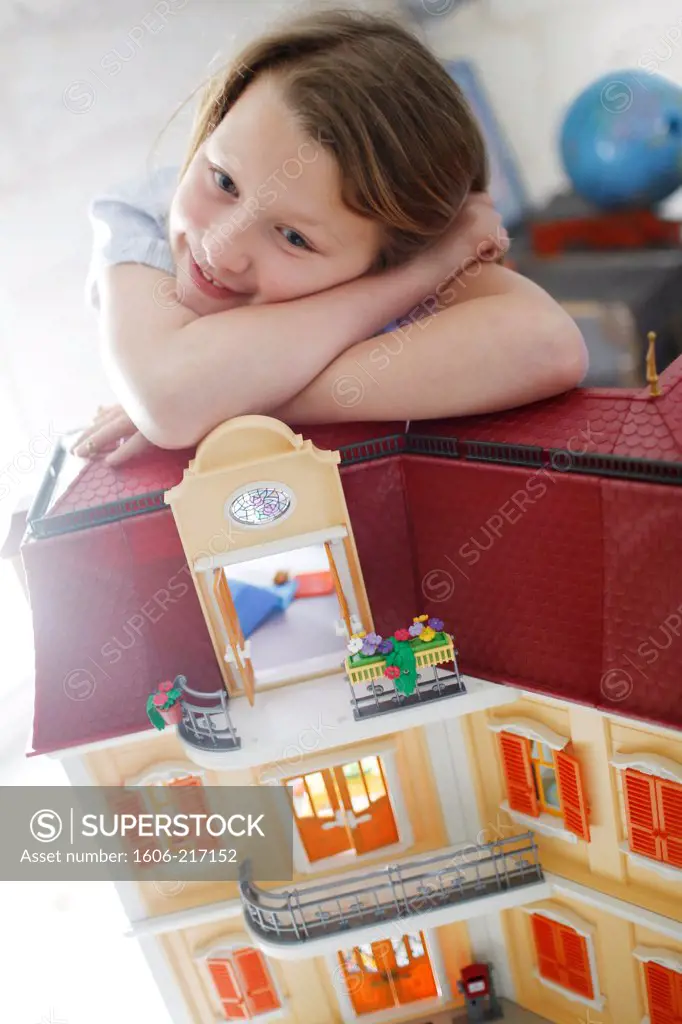 A girl playing with her dollhouse