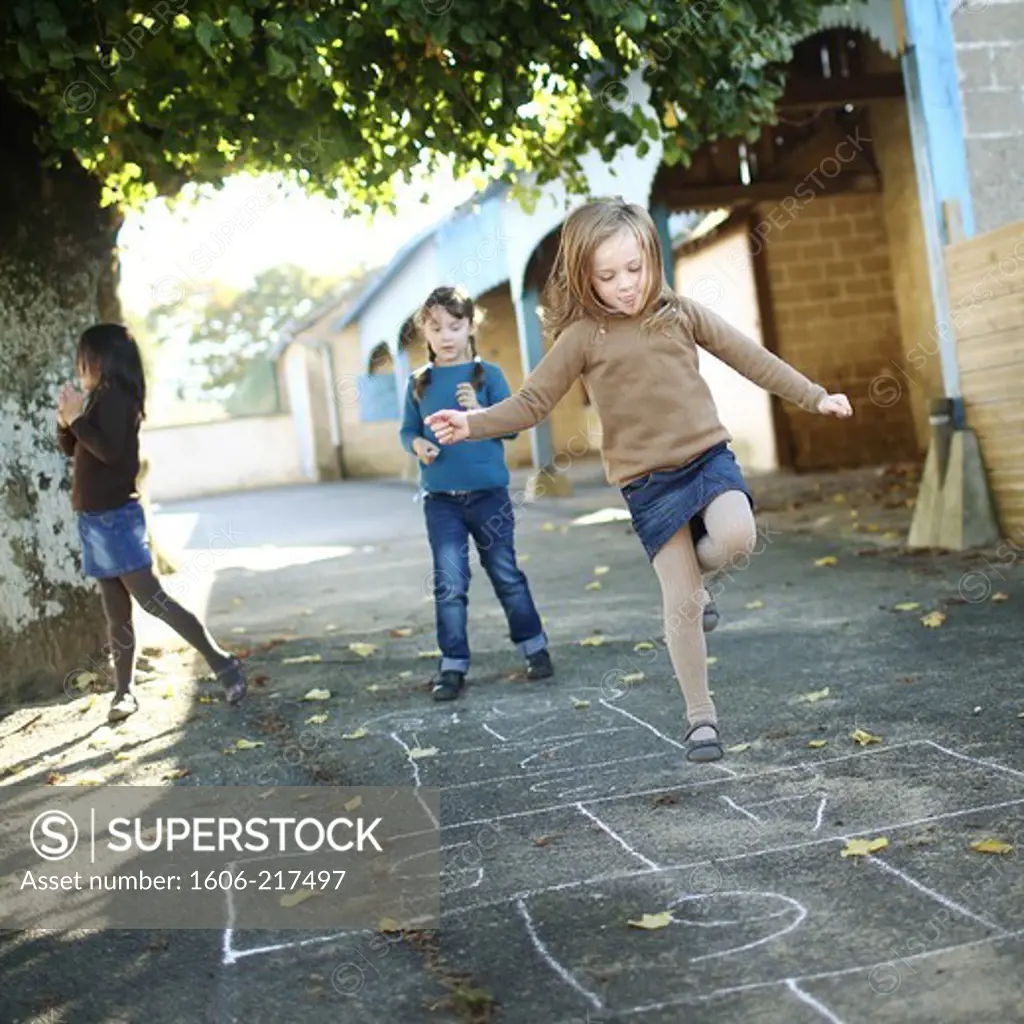 Girls playing hopscotch in a schoolyard