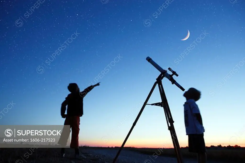 Seine et Marne. Boys 9 and 6 years watching the moon and stars, telescope
