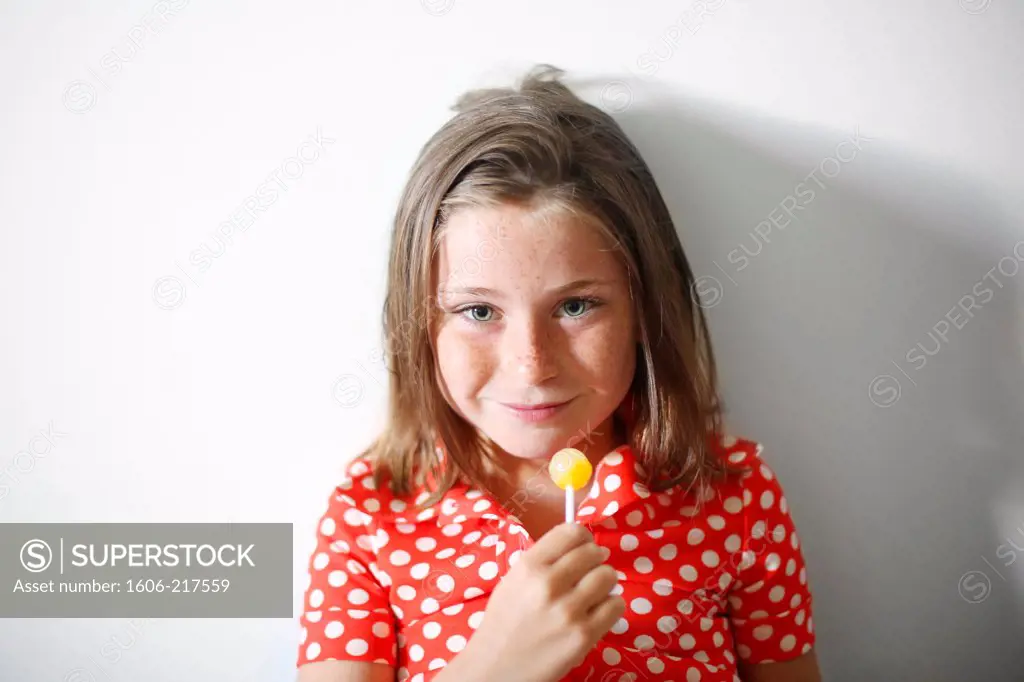 a little girl eating a lollipop