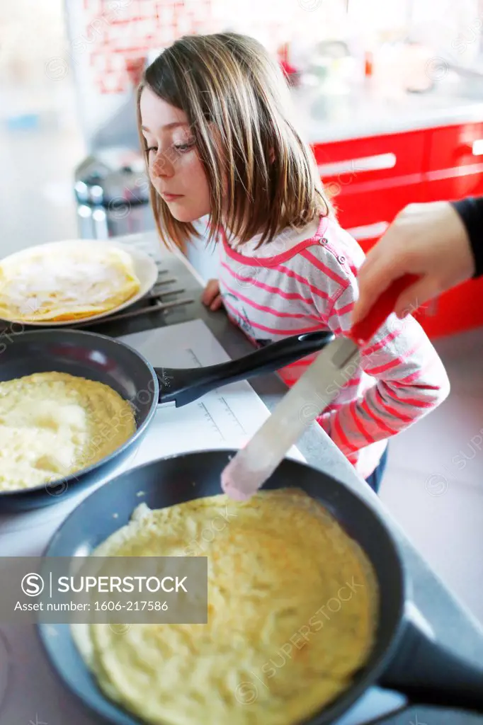 A little girl making crepes