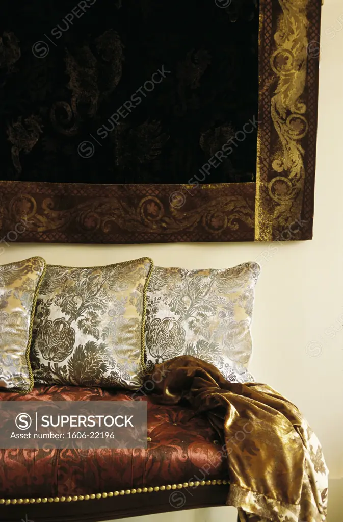 Intérieur salon baroque, coussins sur banquette et tenture en velours frappé d'or et d'argent