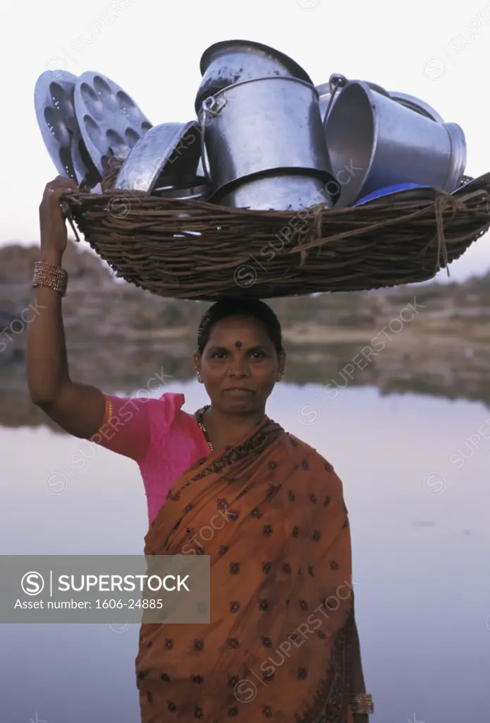 India, Karnataka, Hampi, river Tungabhadra, woman carrying dishes