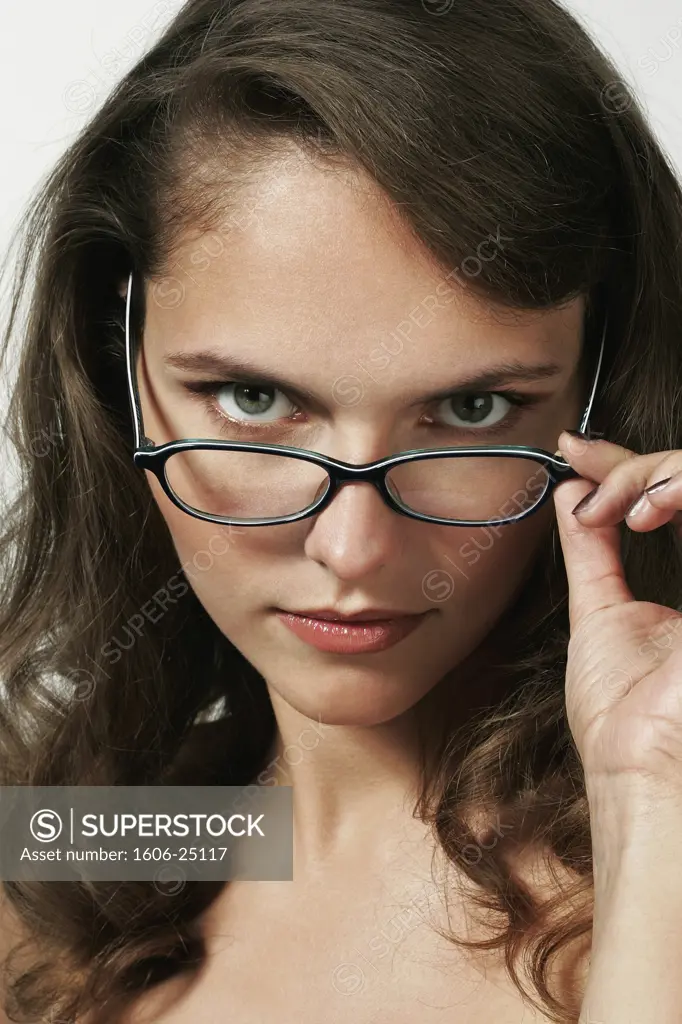 IN*Portrait jeune femme brune posant, regardant par dessus ses lunettes de vue(Iléna)