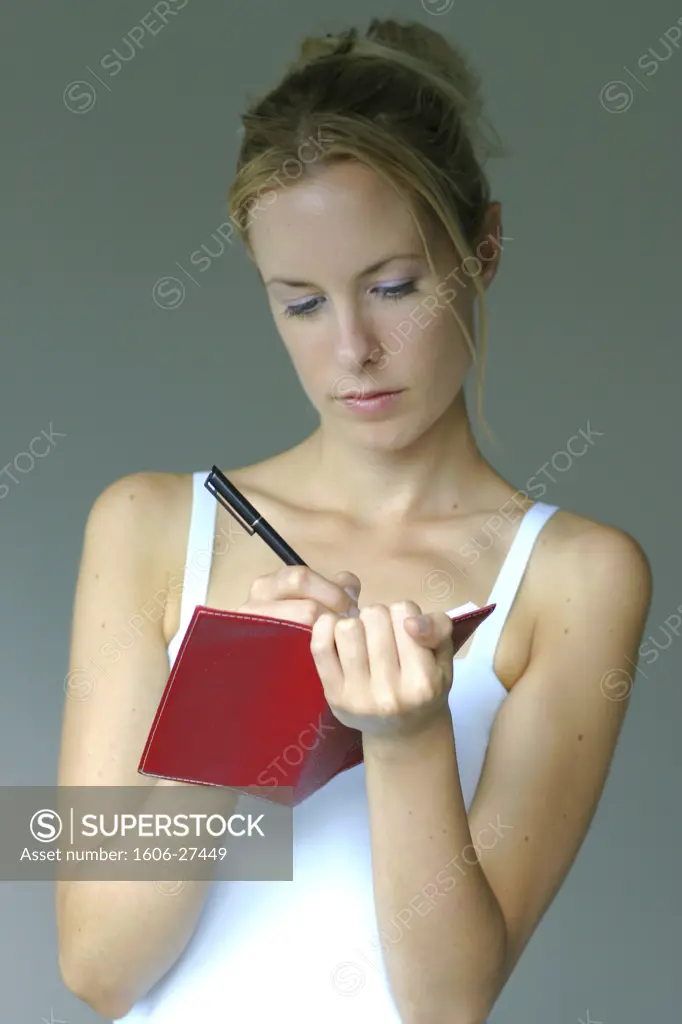 Portrait girl, white background, writting on agenda, red blanket, blue background