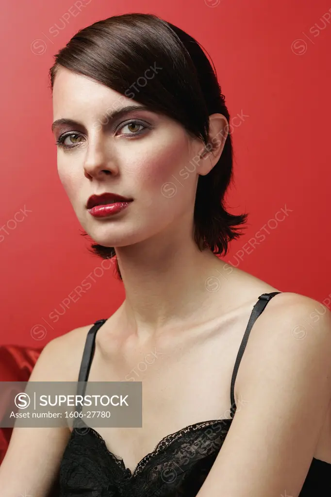N*Portrait Ema posant, maquillée, débardeur noir, fond rouge