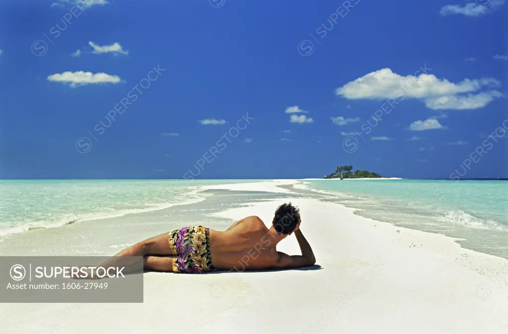 Maldives, man turned on his back, swimsuit, lying down a sandbar, blue sky