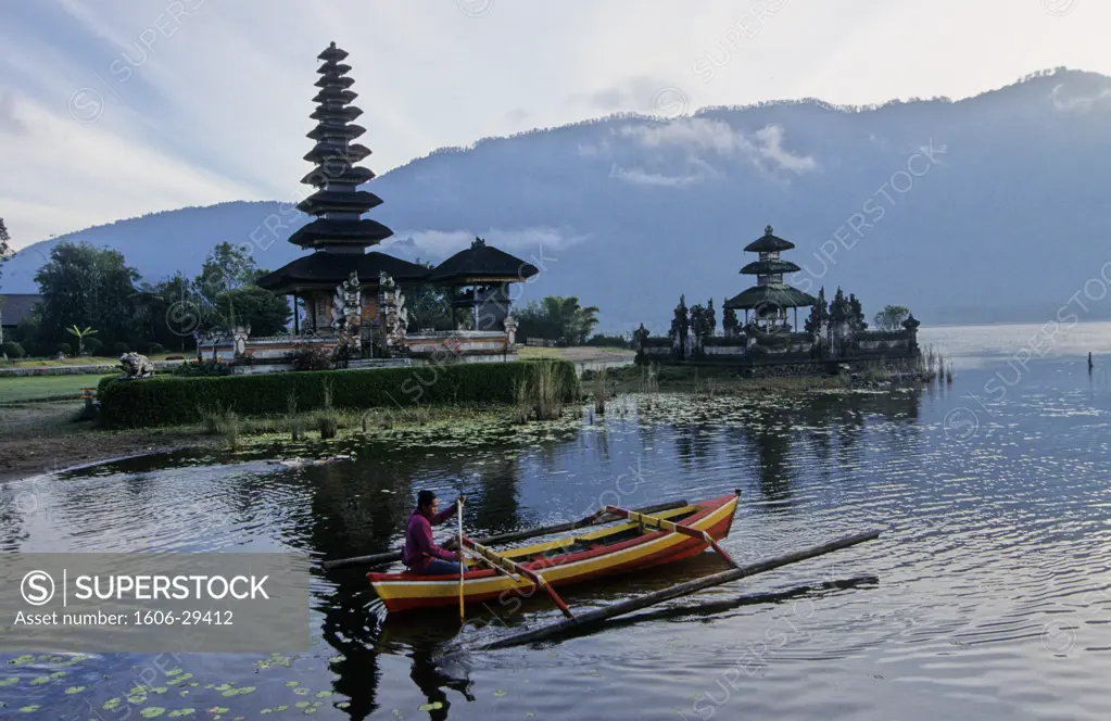 Indonesia, Bali, near Bedugul, Pure Ulun Danu Bratan temple by a lake, man on jukung (small boat) in the foreground