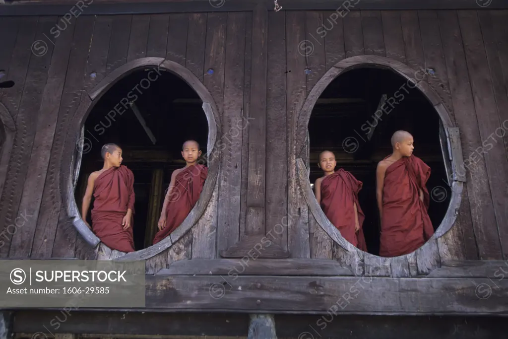 Burman, Shan plateau, near Nyaugshwe, Shwe Yan Pyay teak-made monastery, young monks looking on the outside through oval windows