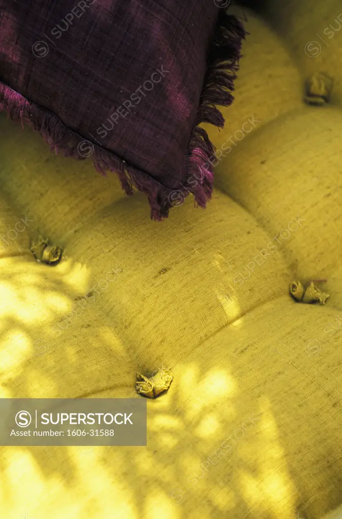 Close up on yellow linen cushion, plum colour cushion