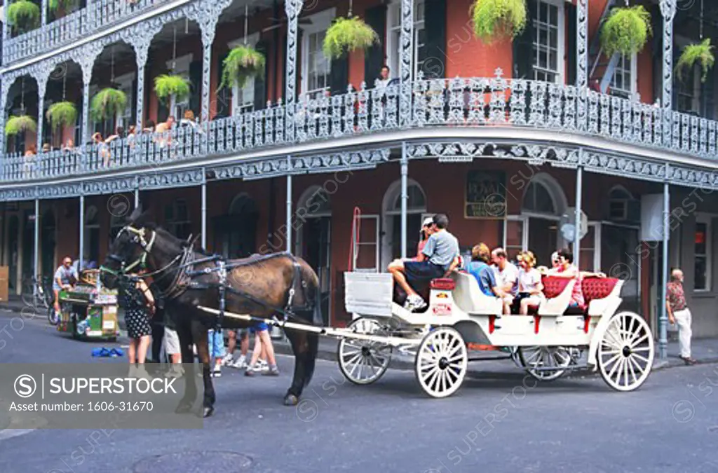 USA, Louisiana, New Orleans, Vieux Carré, junction of Royal and Dauphine street, tourists in horse-drawn carriage, people sitting at tables, colonial house