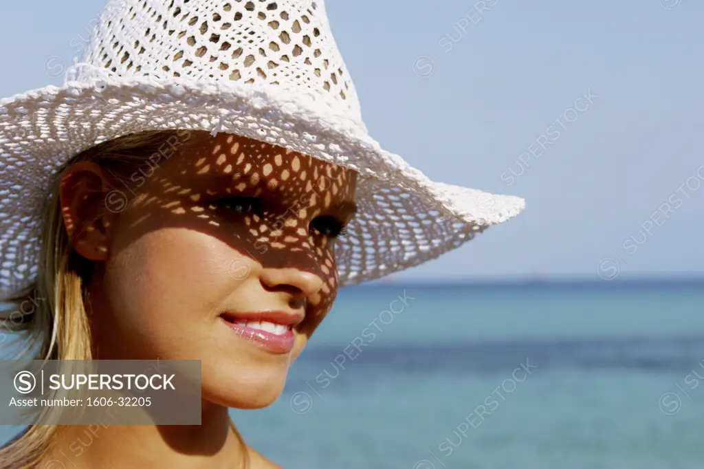 Portrait woman smiling, seaside, white hat