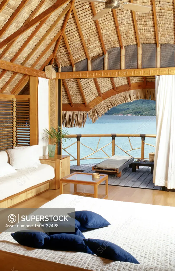 Polynesia, bedroom interior, balcony and blue sea in background
