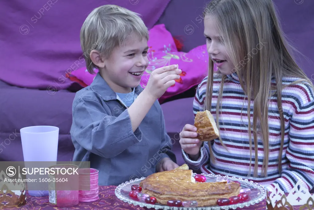 Children smiling, eating "galette des Rois" (cake eaten in France on Twelfth Night)
