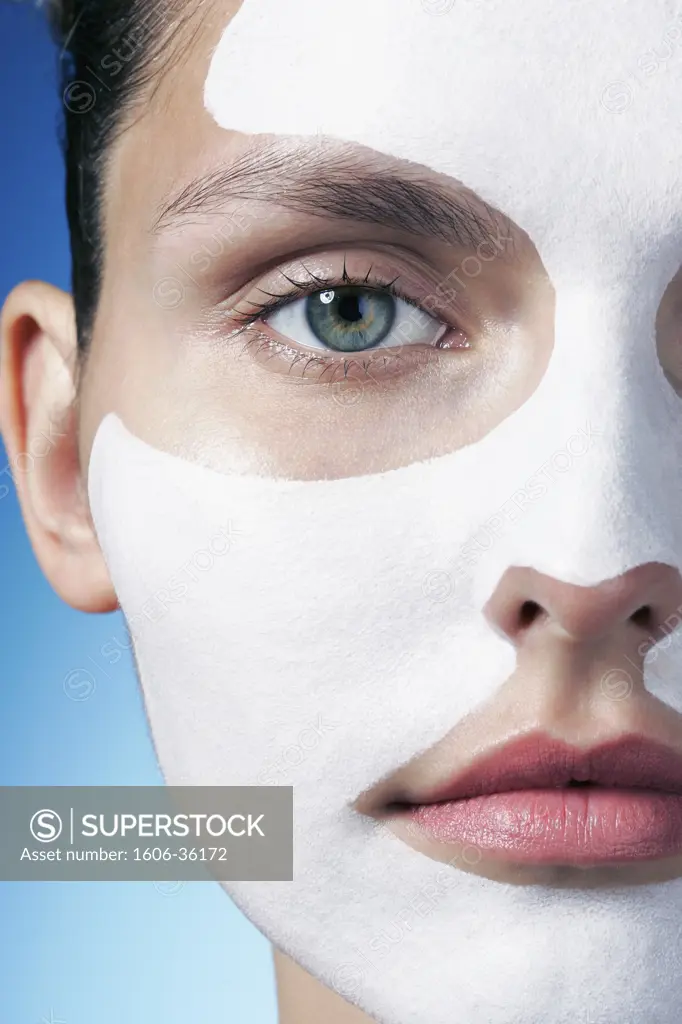 Portrait woman posing, beauty mask on face, close-up on half face, blue background