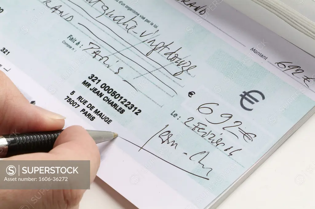 Close-up on someone's hand signing a check