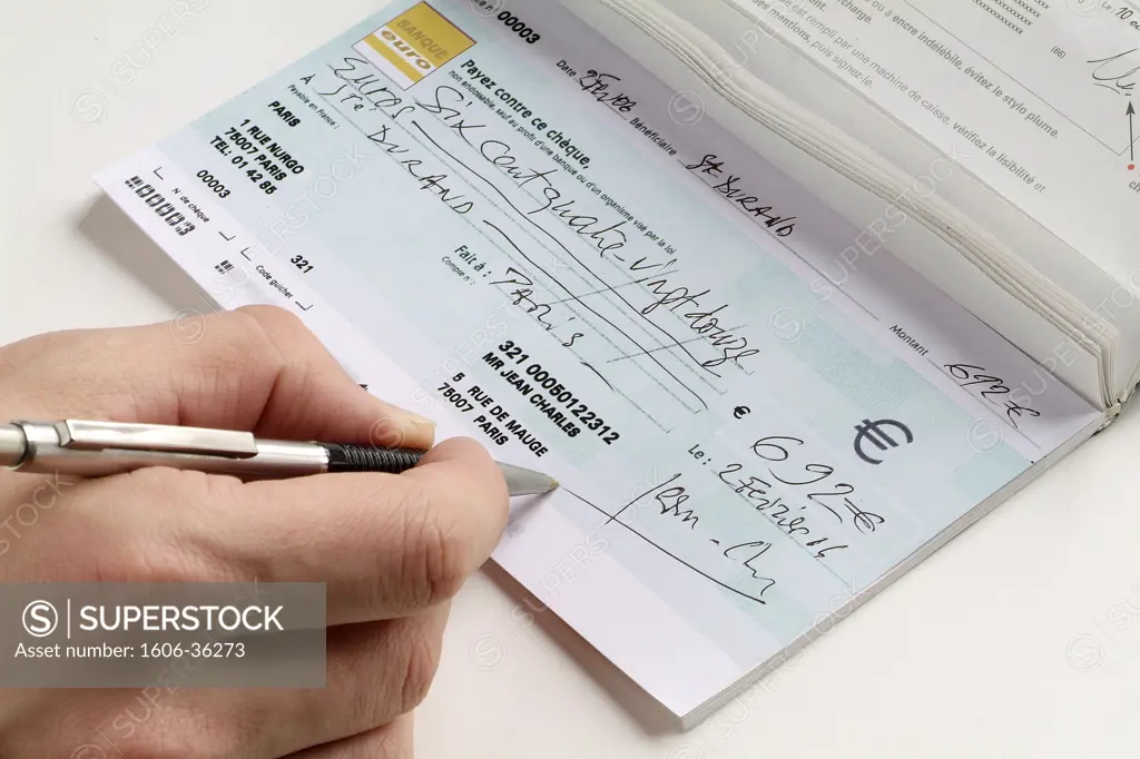 Close-up on someone's hand signing a check