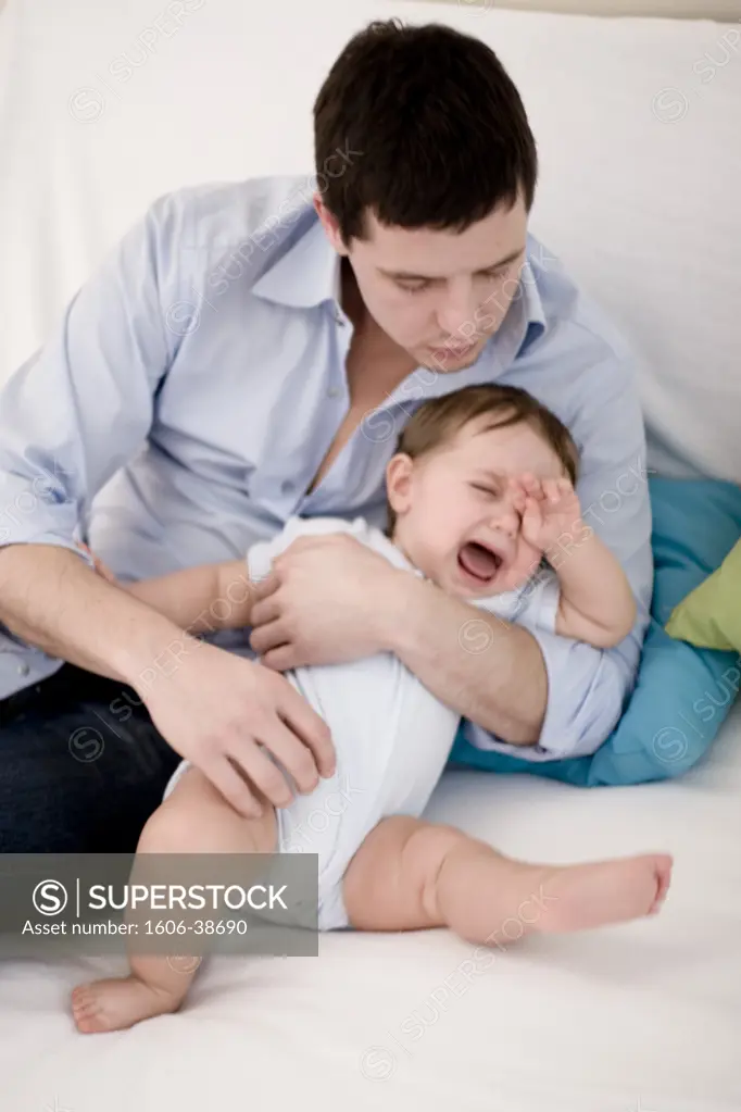 Man holding baby crying