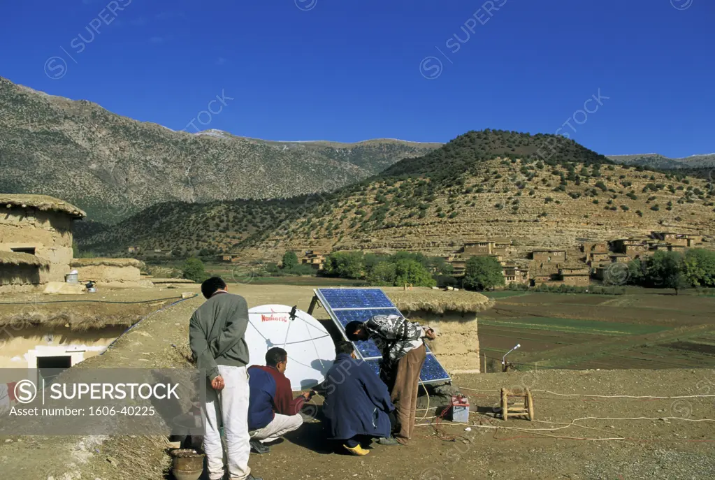 Morocco, Hauts Atlas, man installing solar board and parabola
