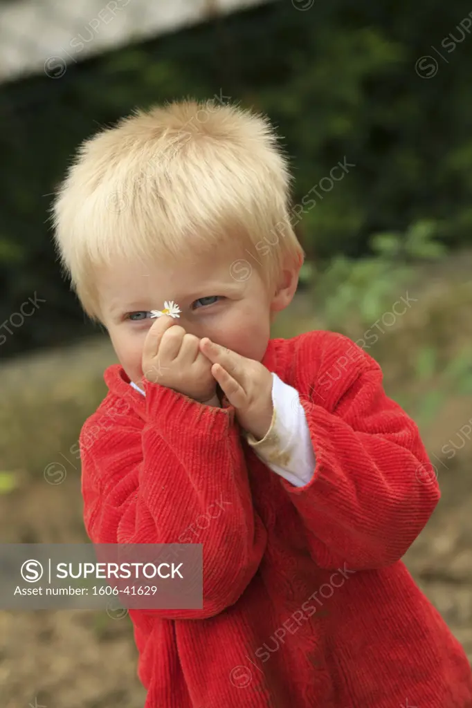 Young boy holding a flower