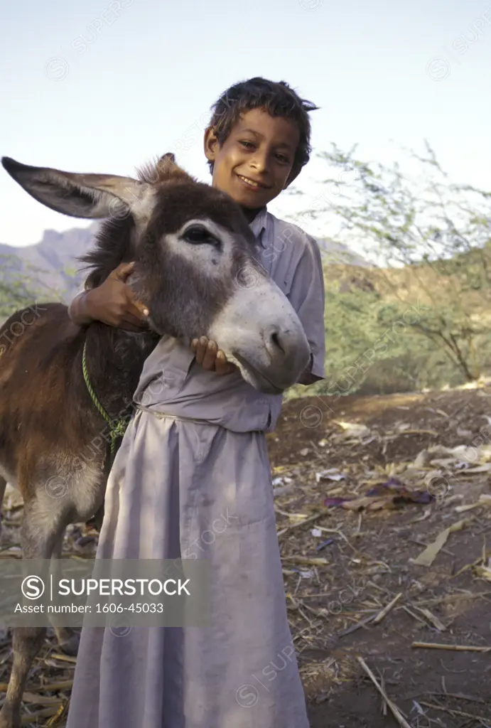 Boy wearing a djellaba with a donkey