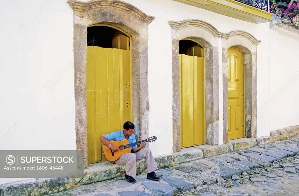 Brazil, Costa Verde, Parati, man playing guitar in the street
