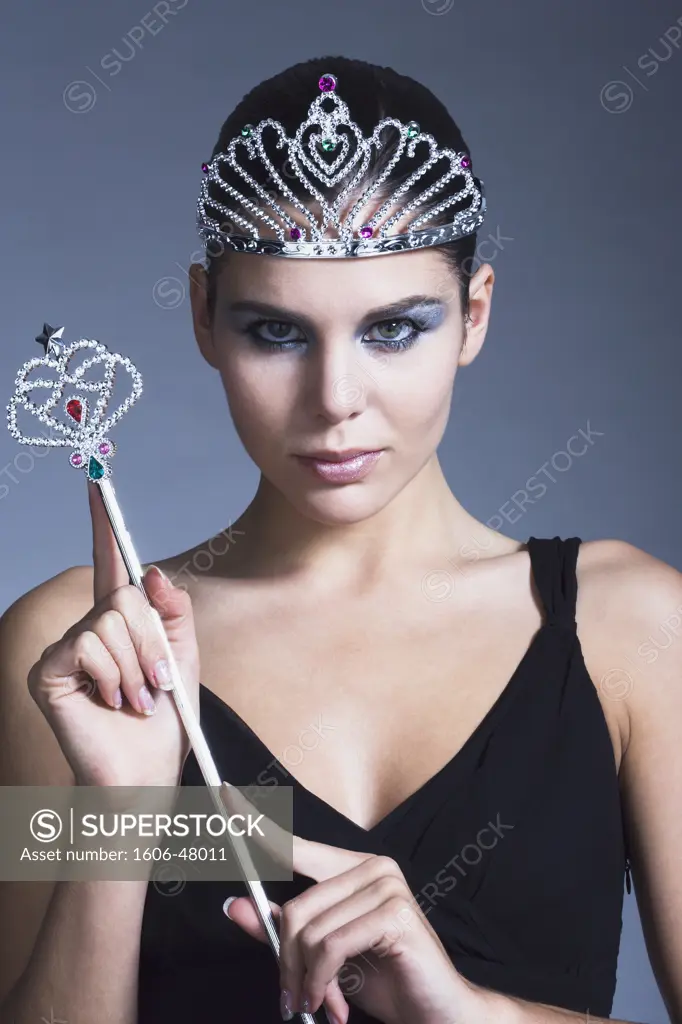 Young woman holding fairy wand, tiara, black dress