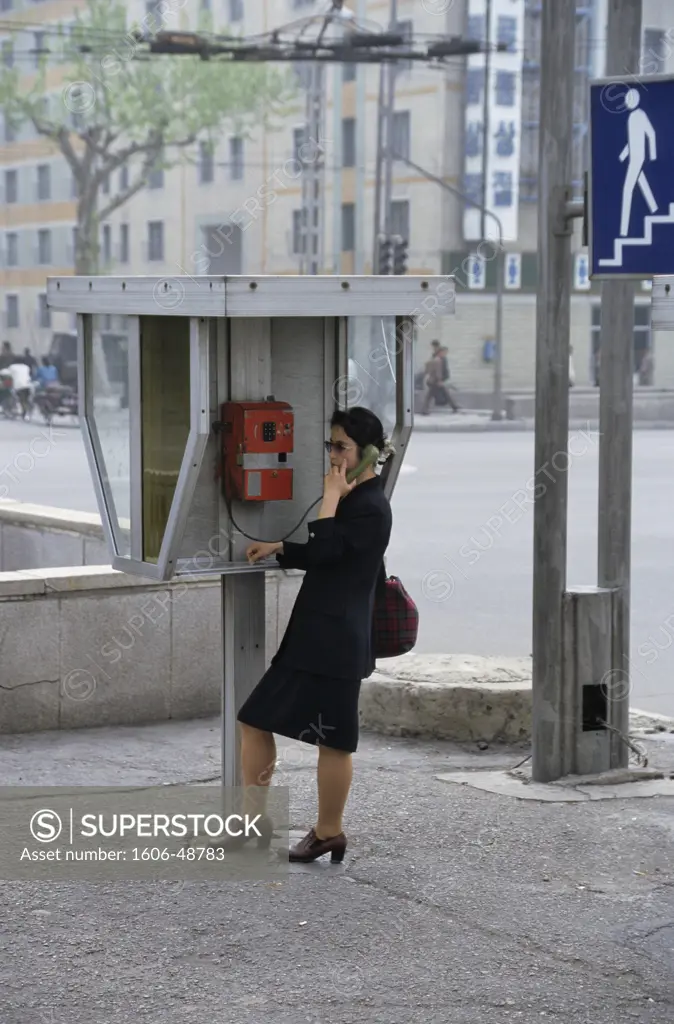 North Korea, Pyongyang, downtown, telephone booth and woman calling