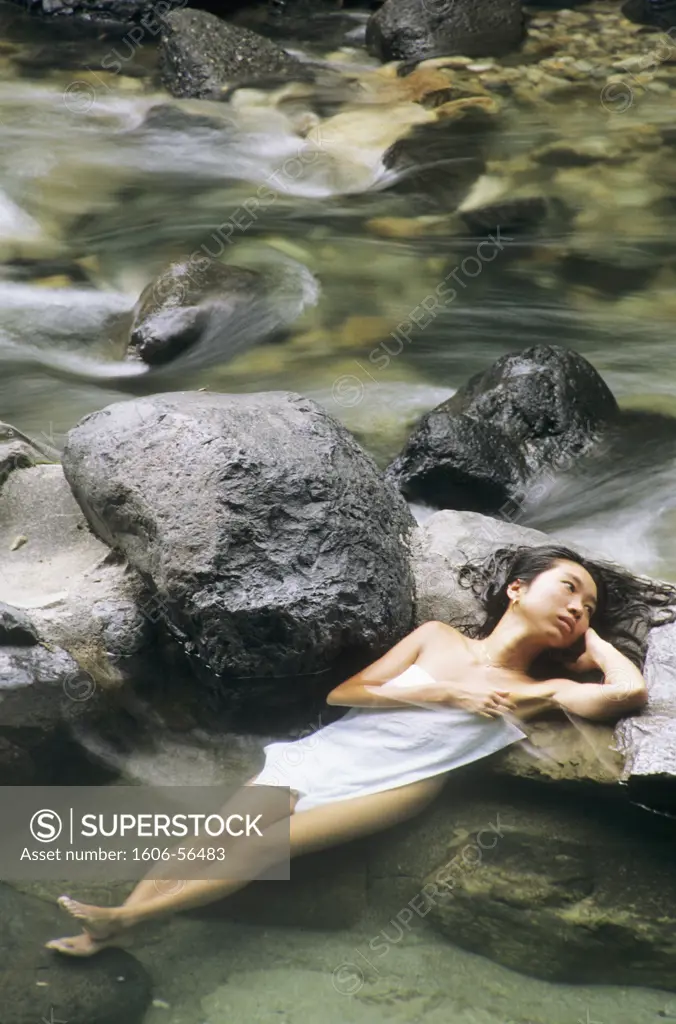 Japon, Takaragawa, station thermale, femme nue, serviette sur poitrine, allongée dans l'eau sur rochers