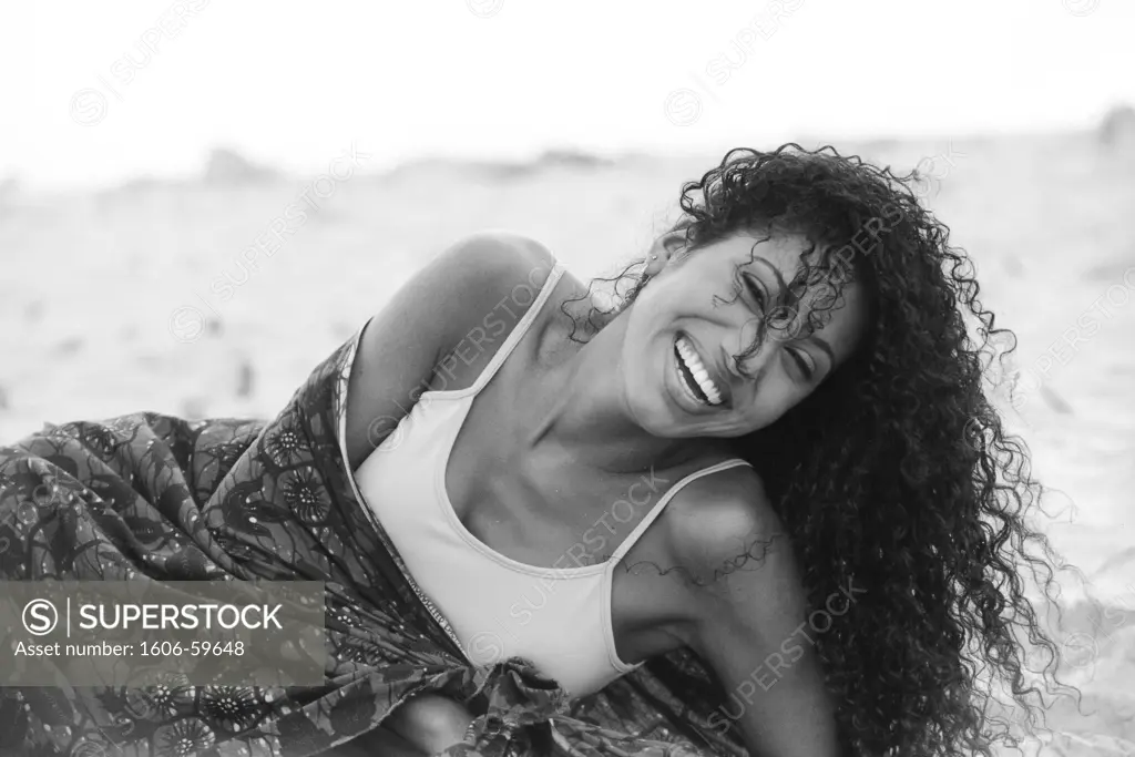 BLACK AND WHITE, PORTRAIT YOUNG WOMAN LAUGHING, ON BEACH