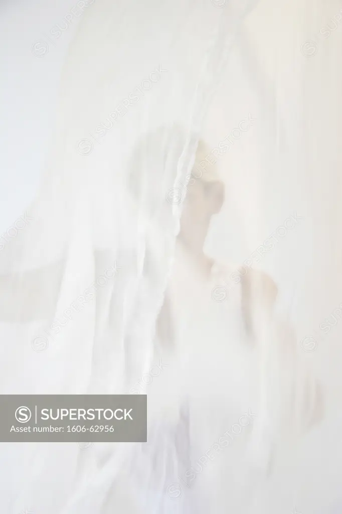 Woman's silhouette behind lace curtain