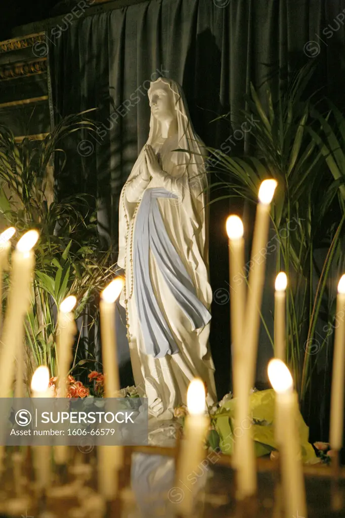 France, Ile-de-France, Paris, église de la Madeleine, statue of Virgin Mary and candles