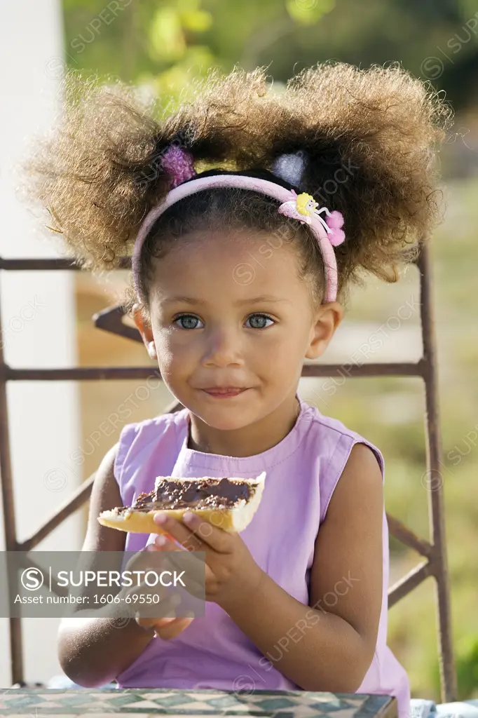 Little girl eating bread and chocolate