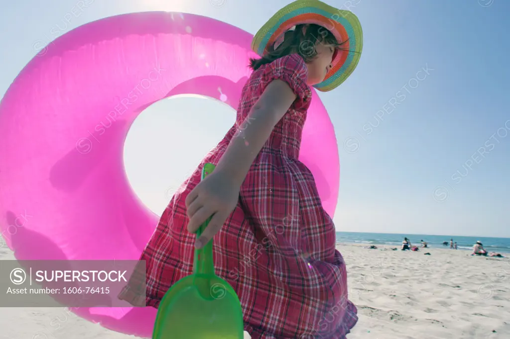 France, Languedoc, Hérault, Montpellier, little girl on the beach with inflatable ring