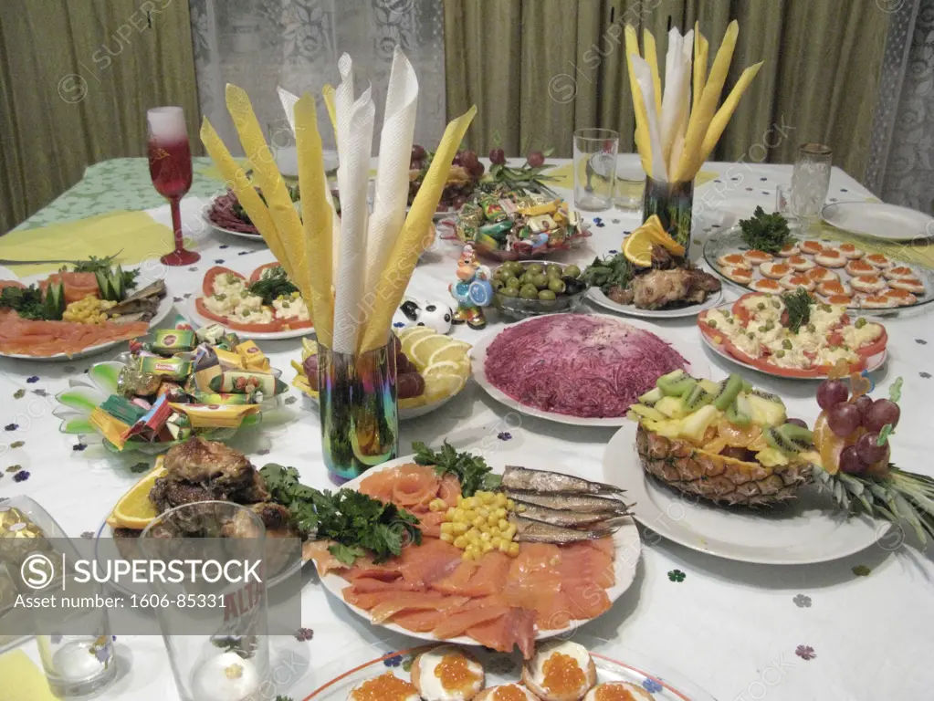 Russia, meal of typical Russian Christmas: celerdka pod shuboy (topcoat of fish), salmon, olives, chocolate, eggs of lumpfish...