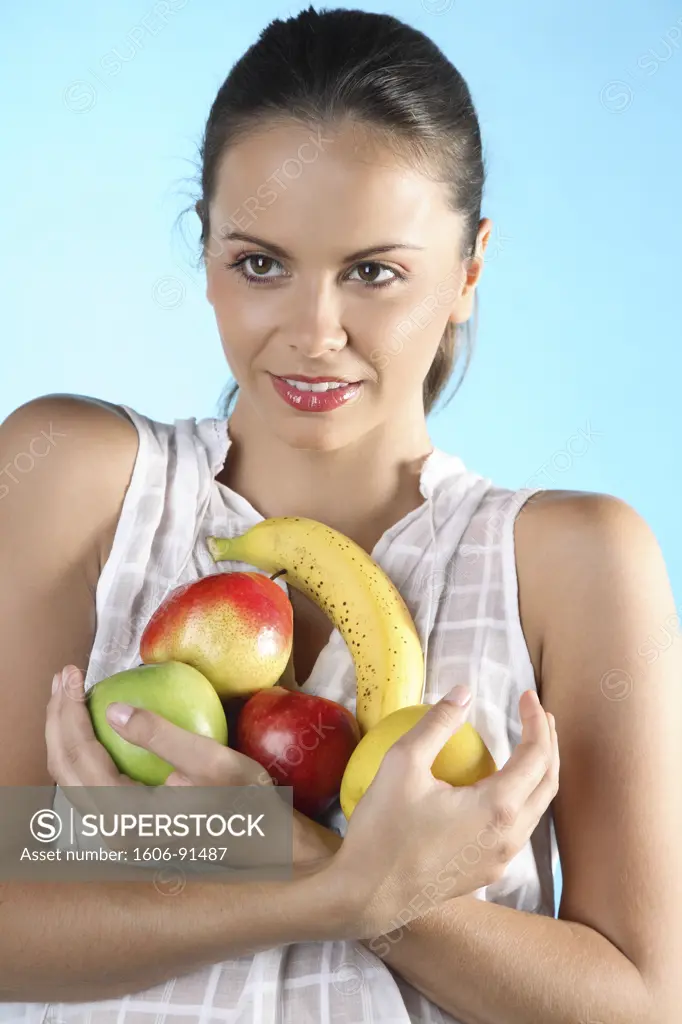 Young woman holding fruits in her arms