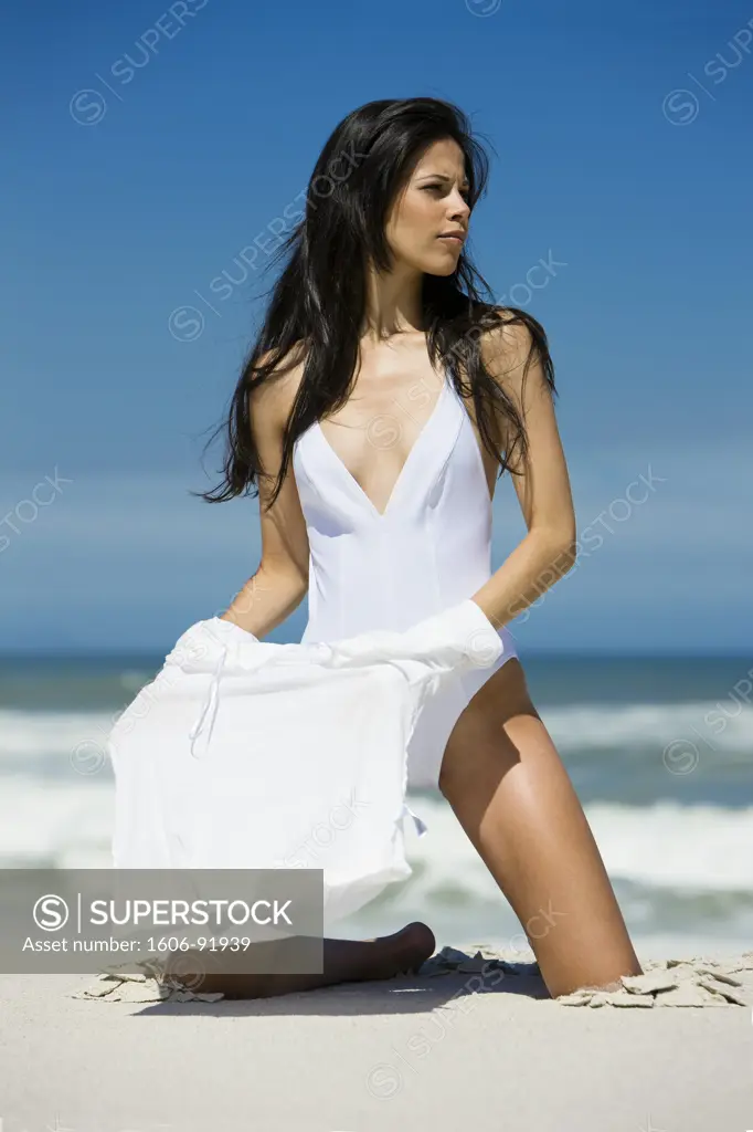 Young woman undressing on the beach
