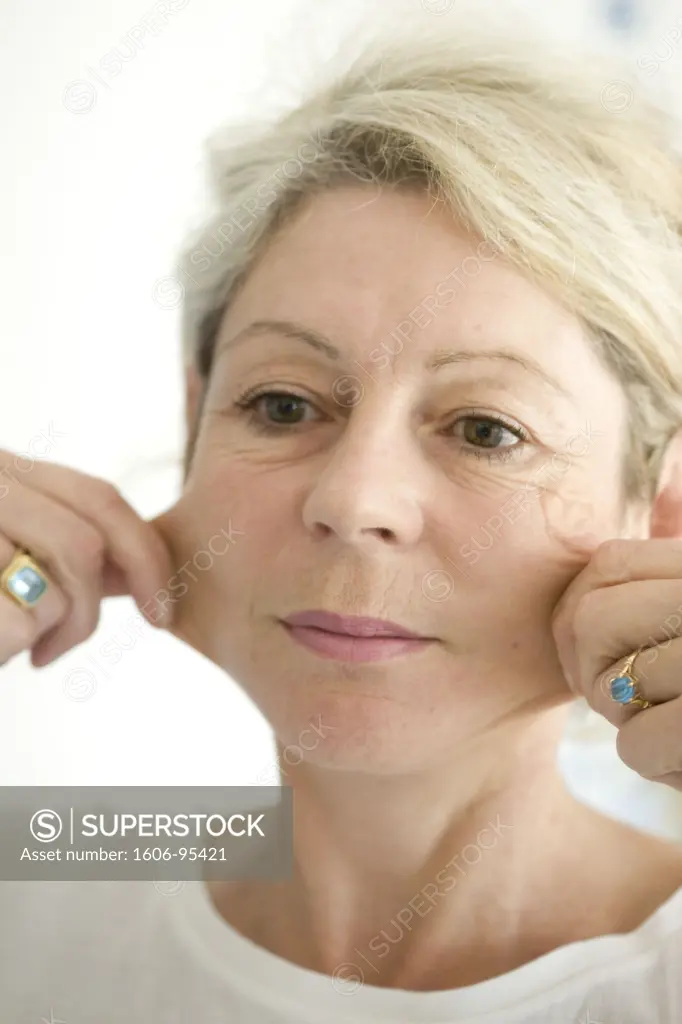 Portrait of woman pinching her cheeks