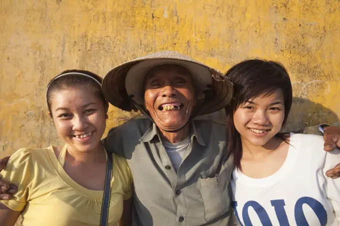 Vietnam,Hoi An,Elderly Fisherman Posing with Young Tourists
