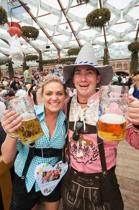 Germany,Baveria,Munich,Oktoberfest,Couple in Baverian Costume Drinking Beer