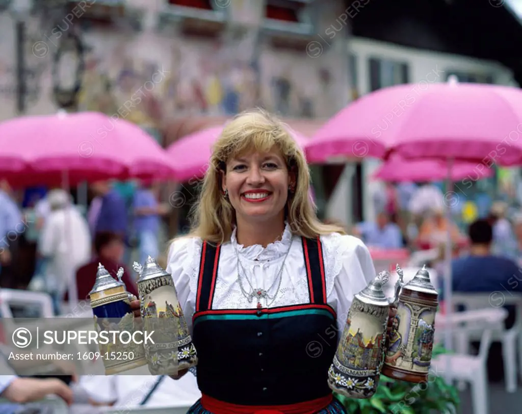 Beer Garden (Biergarten) / Woman in Baverian Costume (Dirndl) holding Beer Steins , Mittenwald, Baveria, Germany