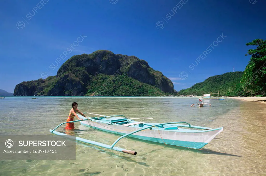 Philippines, Palawan, Bascuit Bay, El Nido, Girl with Outrigger on Tropical Beach