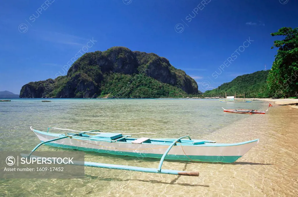 Philippines, Palawan, Bascuit Bay, El Nido, Outrigger on Tropical Beach at Sunset